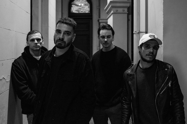 Black and white promo photo of Australian rock band Dream On Dreamer posing together in a narrow hallway.